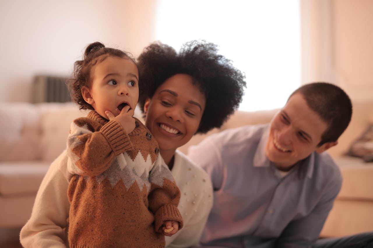 Happy family enjoying time with their child in a cozy living room.
